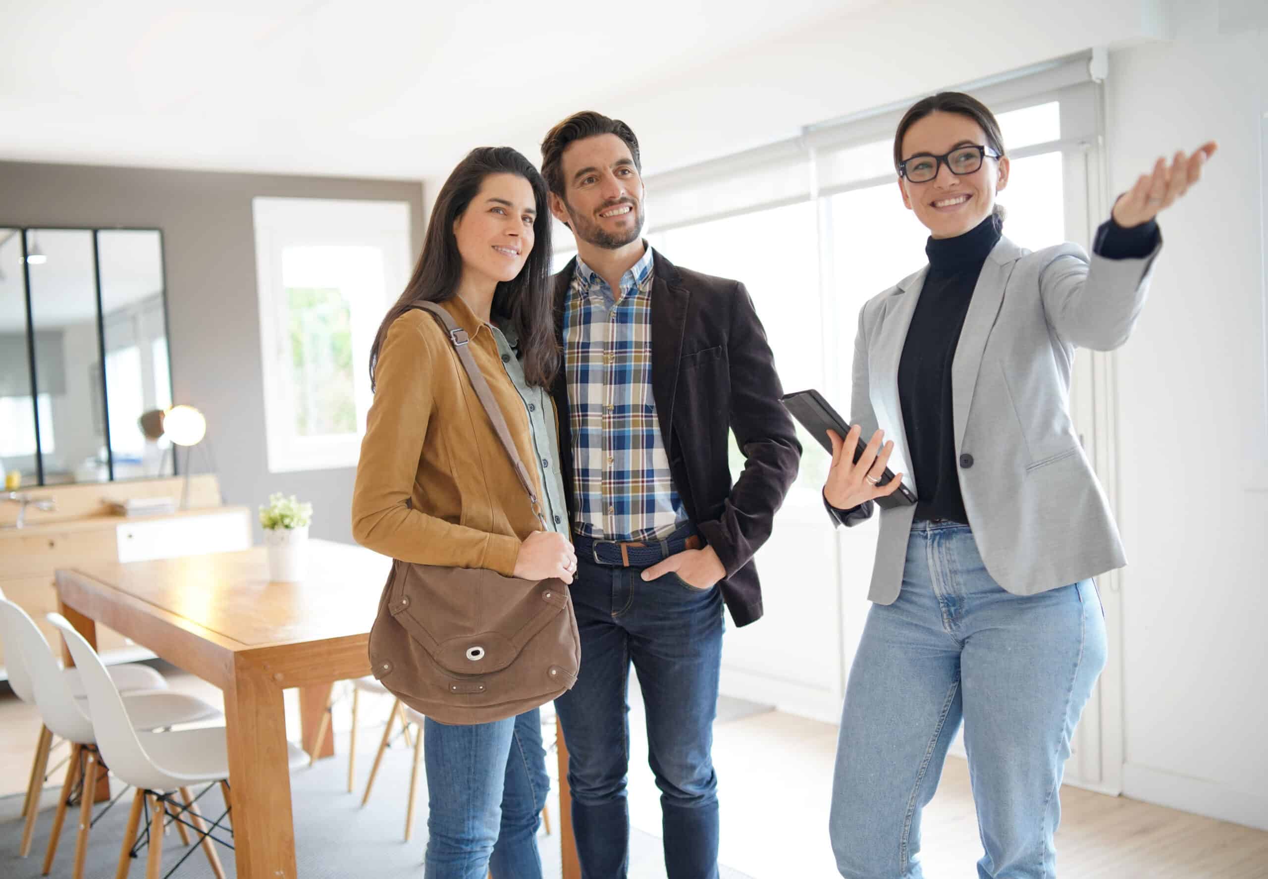 Un agent immobilier fait visiter une maison moderne à un couple séduisant