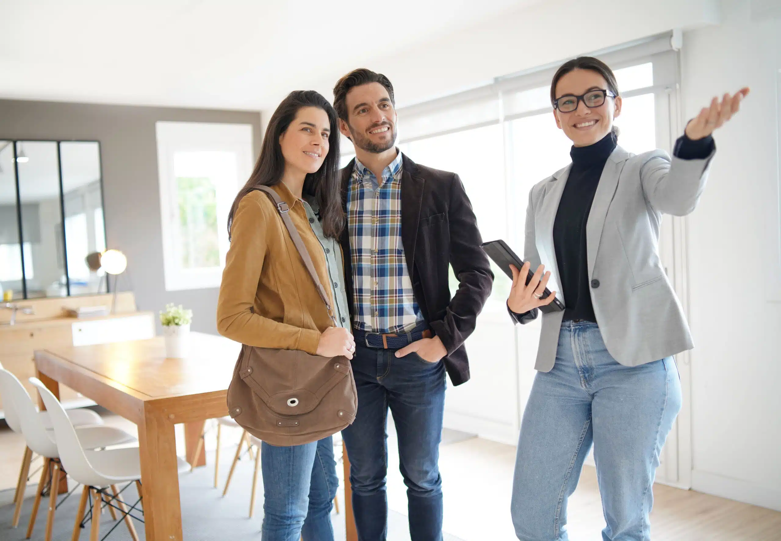 Un agent immobilier fait visiter une maison moderne à un couple séduisant