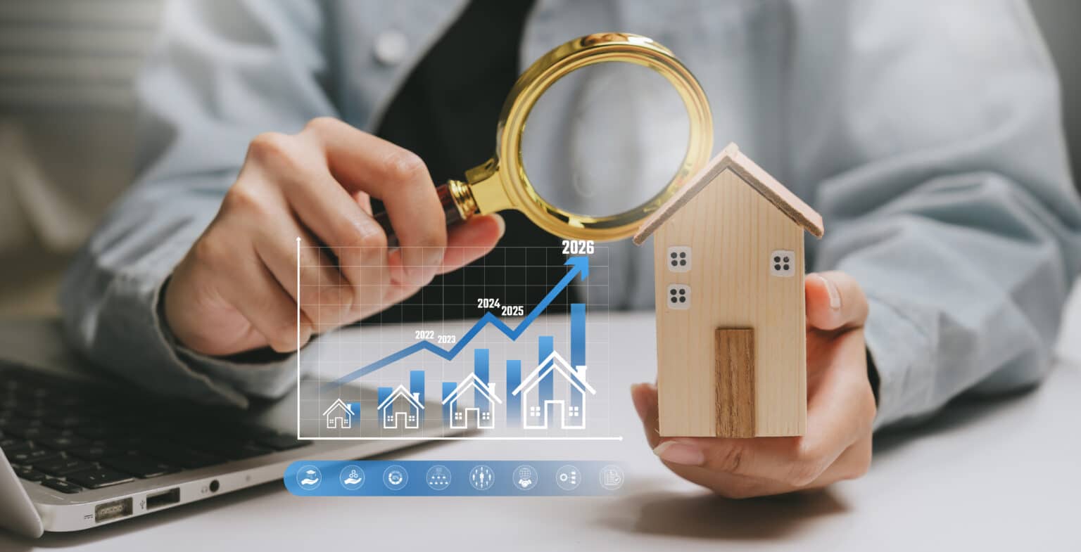 Concept d'analyse immobilière : inspection manuelle d'une maison en bois à la loupe et graphique de l'évolution des prix. Évaluation immobilière, étude de marché, décision d'investissement, prévision de croissance.