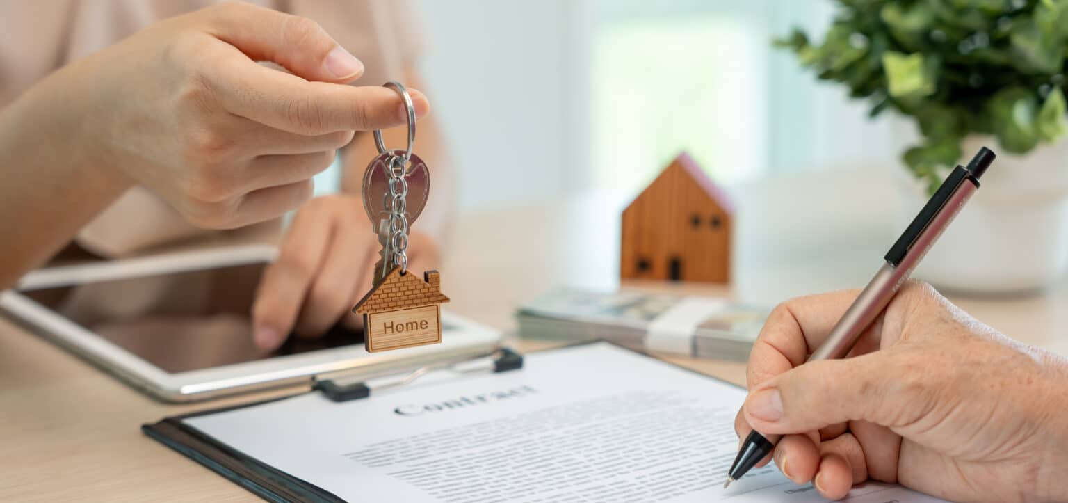 Location, mise en location et vente de maison. Agent immobilier souriant, tenant les clés pour le nouveau propriétaire. Location de maison, Vente, prêt, crédit, assurance, Vendeur, concessionnaire, paiement échelonné, achat, vente, emménagement