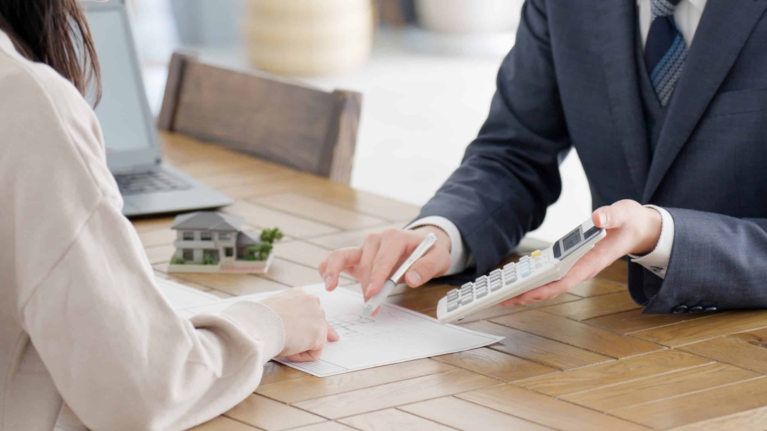 Un homme d'affaires calcule une estimation immobilière.